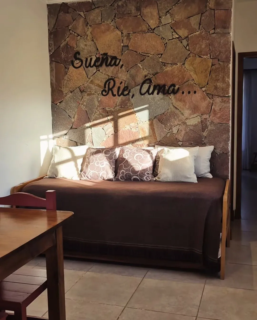 Living con pared de piedra y sillón cama